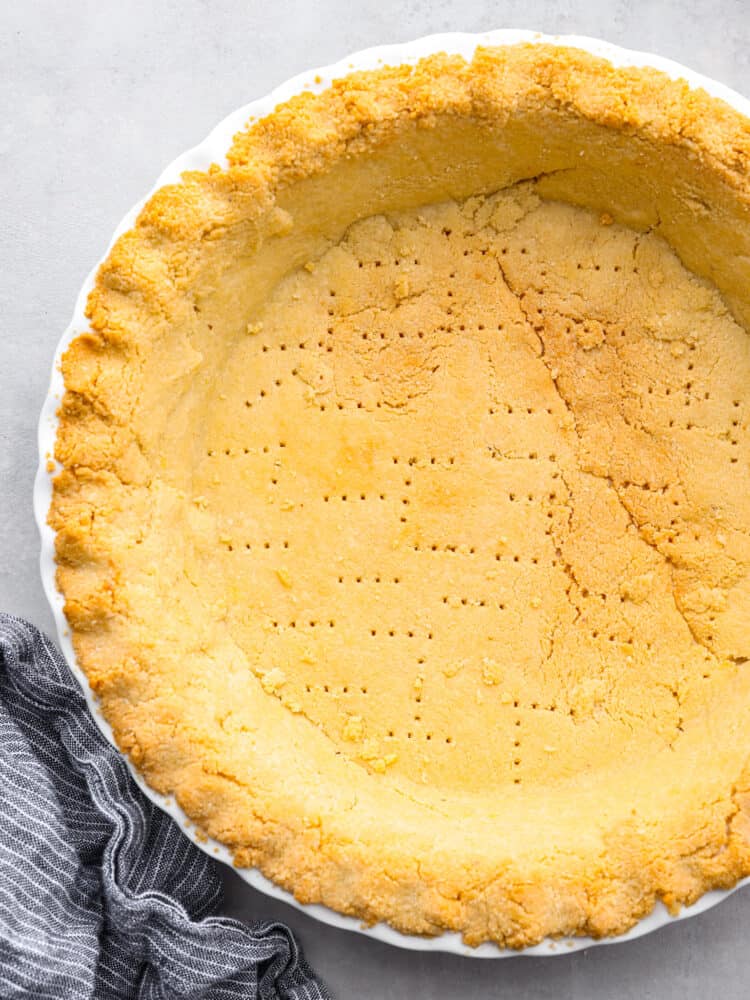 Not only is this gluten-free pie crust buttery and delicious, but it only takes 4 simple ingredients to make! It’s also keto-friendly, making it the perfect diet-conscious choice for Thanksgiving! Top-down view of a baked gluten-free pie crust.